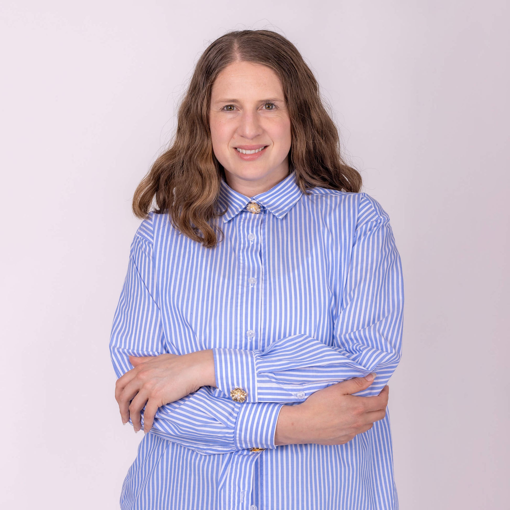 woman wearing shirt and gold flower with pearls button covers